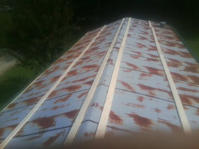 Rusted metal roof panels with new wood purlins before replacement — Storm Damage Roof Repair in Swanzey by Roofing Brothers